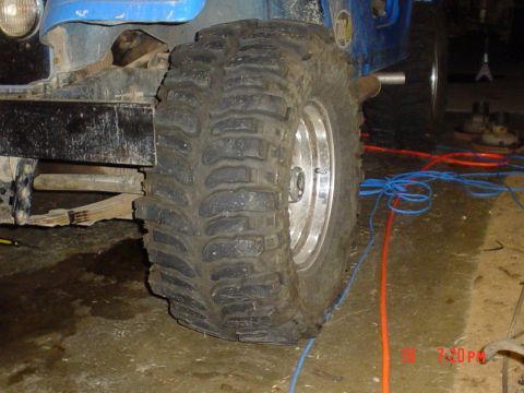 1983 Ford Bronco - This image shows a close-up of a large off-road tire and suspension components on a blue vehicle, not definitively a 1983 Ford Bronco.