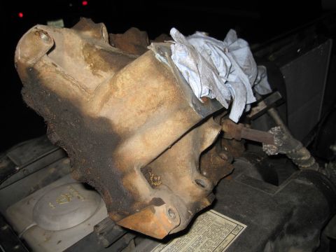 1989 Ford Bronco - An engine part, covered in rust and grime, is shown with a blue cloth draped over it.