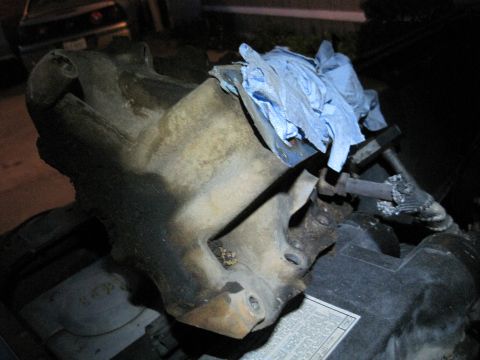 1989 Ford Bronco - Close-up of a greasy engine component, partially covered with blue shop towels.