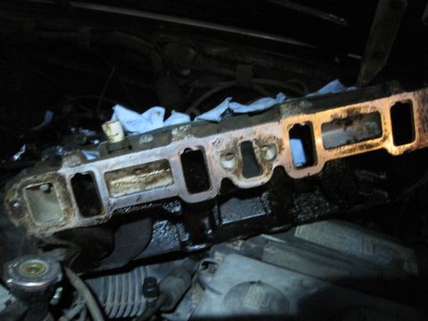 1989 Ford Bronco - Close-up view of an engine intake manifold during reassembly.