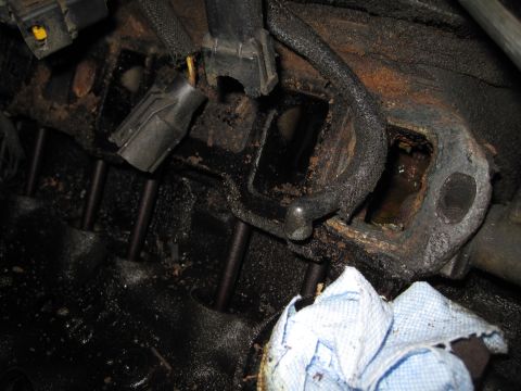 1989 Ford Bronco - Close-up of an engine block, showing spark plug wire connectors and a dirty cloth.