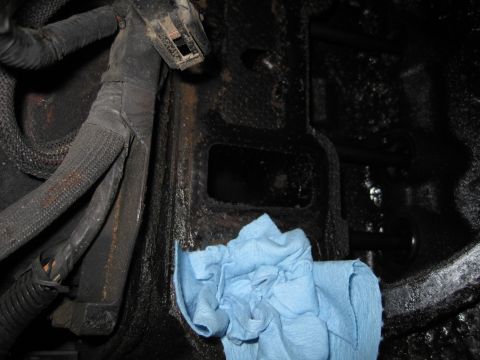 1989 Ford Bronco - Close-up view of an engine block with a wiring harness and a blue rag, likely during reassembly.