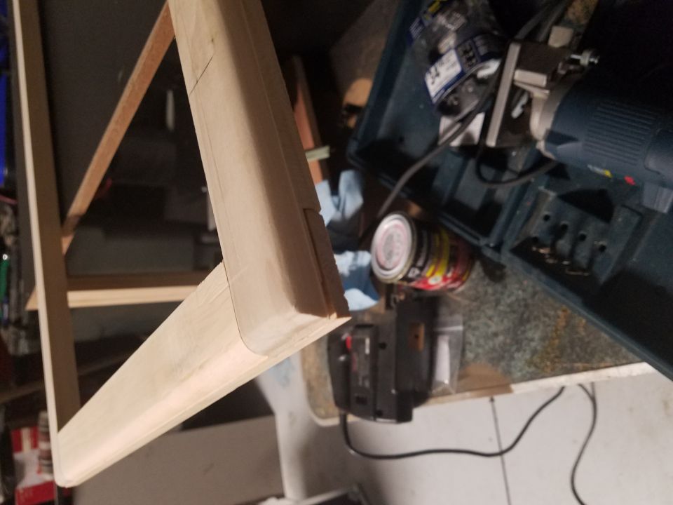 Wooden frame with woodworking tools and cans of paint in the background