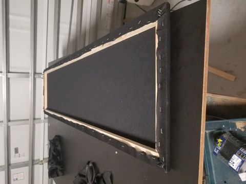 1994 Ford Bronco - A speaker enclosure is shown from the back, revealing its wooden frame and fabric covering.