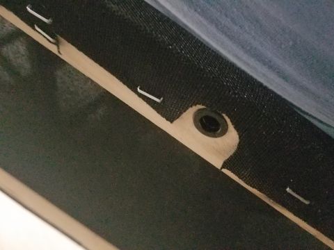 1994 Ford Bronco - Staples and a grommet are visible on the underside of some upholstery, possibly from a car interior.