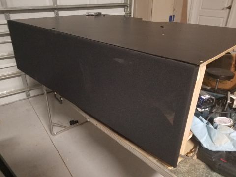 1994 Ford Bronco - A large black speaker enclosure is shown on a metal stand, with visible wood framing and garage background.