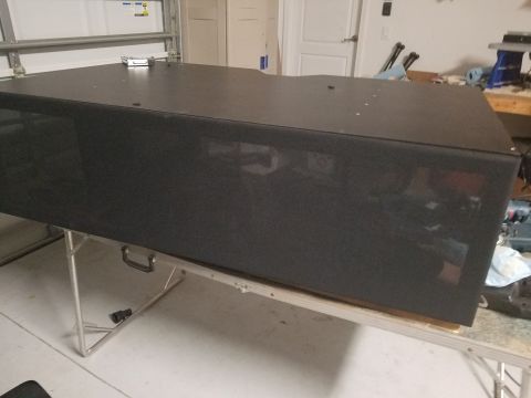 1994 Ford Bronco - A large black speaker box is placed on a folding table in a garage setting.