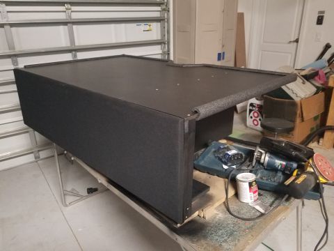 1994 Ford Bronco - A custom subwoofer box is shown on a workbench, surrounded by tools and equipment.