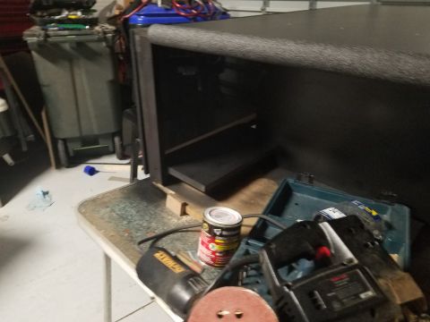 1994 Ford Bronco - A black speaker box sits on a workbench next to a can of spray paint and various power tools.