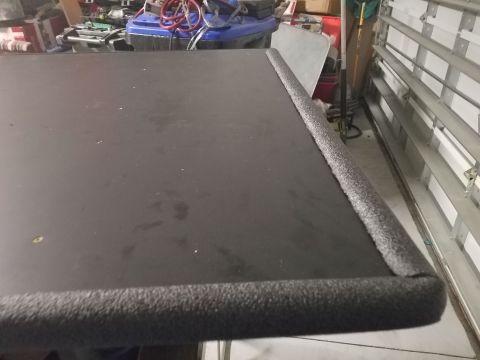 1994 Ford Bronco - A close-up of a black surface with foam edge trim, possibly a car part or accessory, more likely, a custom-built item.