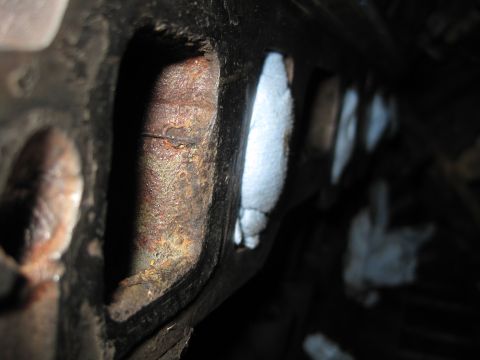 1989 Ford Bronco - A detailed view of a heavily rusted engine part, suggesting significant wear and tear.
