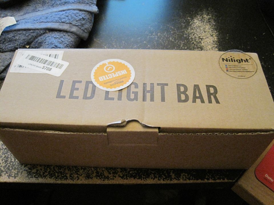 Cardboard box labeled "LED LIGHT BAR" with Amazon inspected sticker and Nilight logo