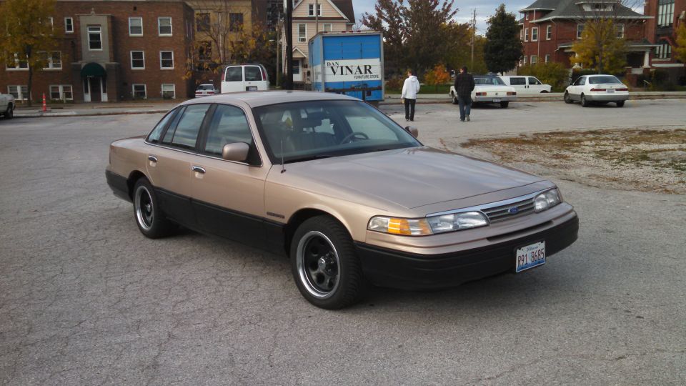 Tan 1995 Mercury Grand Marquis, 3/4 front view. Black trim and wheels