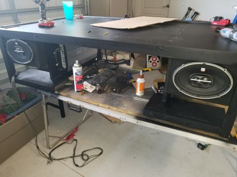 1994 Ford Bronco - Car stereo components, including an amplifier and speakers, are laid out on a table with various tools and supplies.