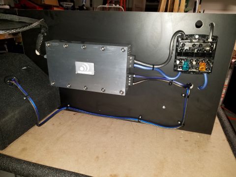 1994 Ford Bronco - Car amplifier and fuse box wiring installed on a black panel, with a subwoofer visible on the left.