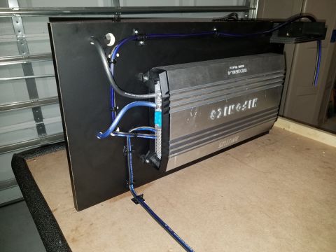 1994 Ford Bronco - A car amplifier is mounted on a black board with blue wiring visible.