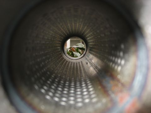1987 Jaguar XJ6 - View from inside a vehicle's exhaust pipe, showing leaves and debris at the opening.
