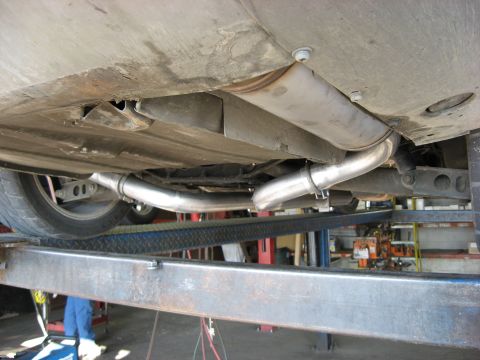 1987 Jaguar XJ6 - Underside view of a vehicle's dual exhaust system, shiny metal pipes and clamps.