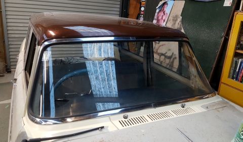 1962 MG B - Interior view of a car, showing the dashboard, steering wheel, and brown roof.