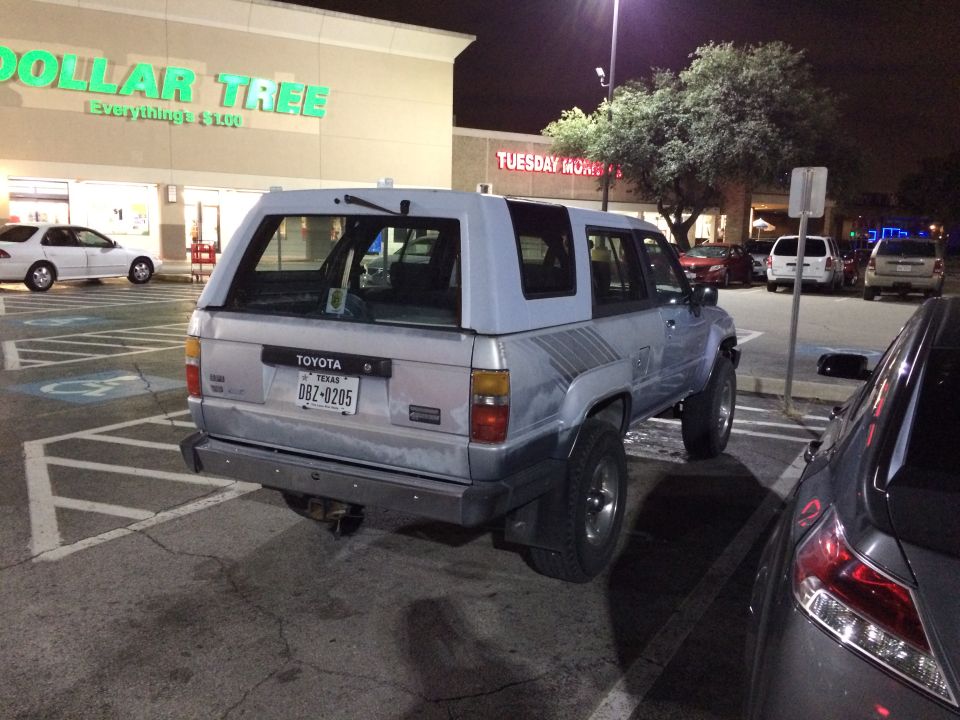 Silver Toyota 4Runner with a light blue camper shell parked at night, Texas license plate DBZ-0205