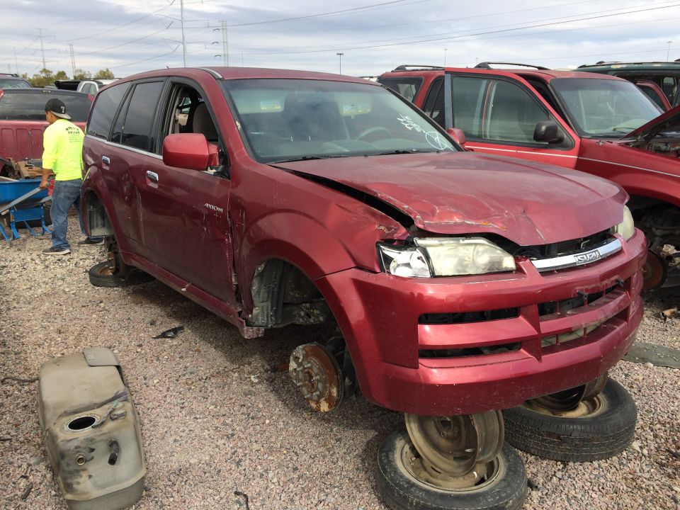 Red SUV missing wheels, front end damaged, Isuzu badge visible