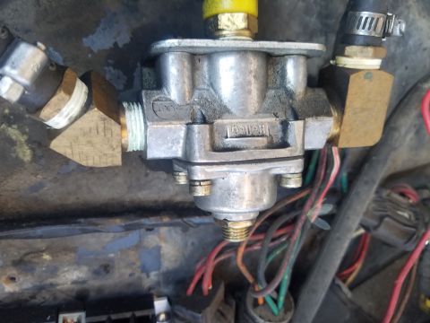 1984 Ford Bronco - Close-up view of a Holley fuel pressure regulator, showing its brass fittings and associated wiring.
