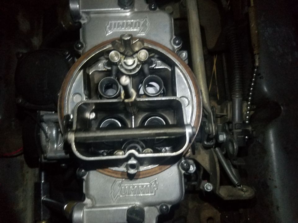 Overhead view of a Summit Racing carburetor with internal components visible.
