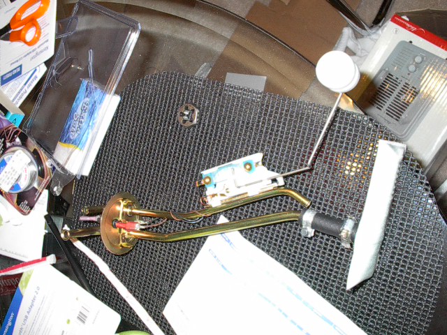 Fuel pump sending unit with float arm and filter on a textured surface