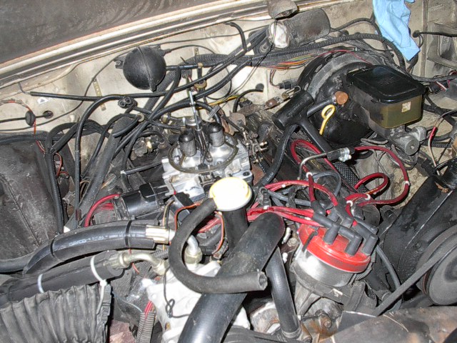 engine bay with carburetor, distributor cap, and brake fluid reservoir