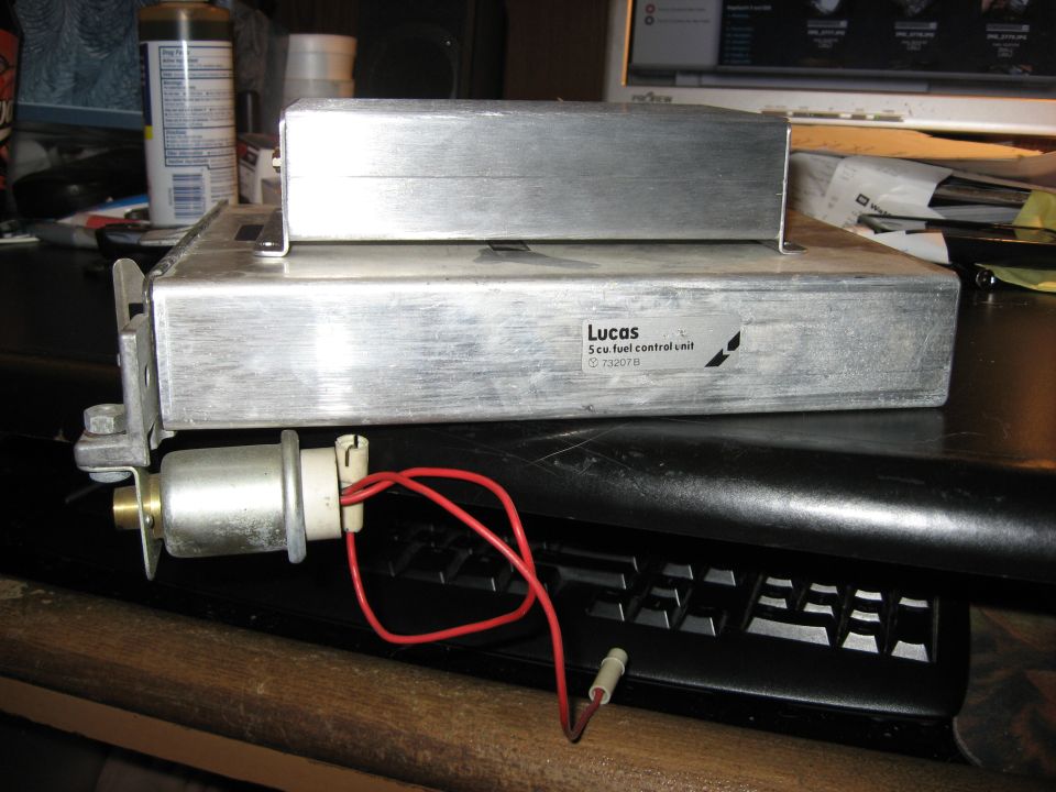 Lucas 5cu fuel control unit with red wires attached, sitting on a keyboard