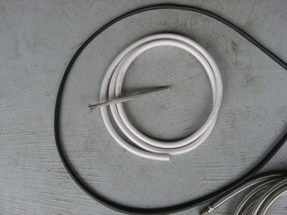 Various hoses and cables on a grey concrete surface.
