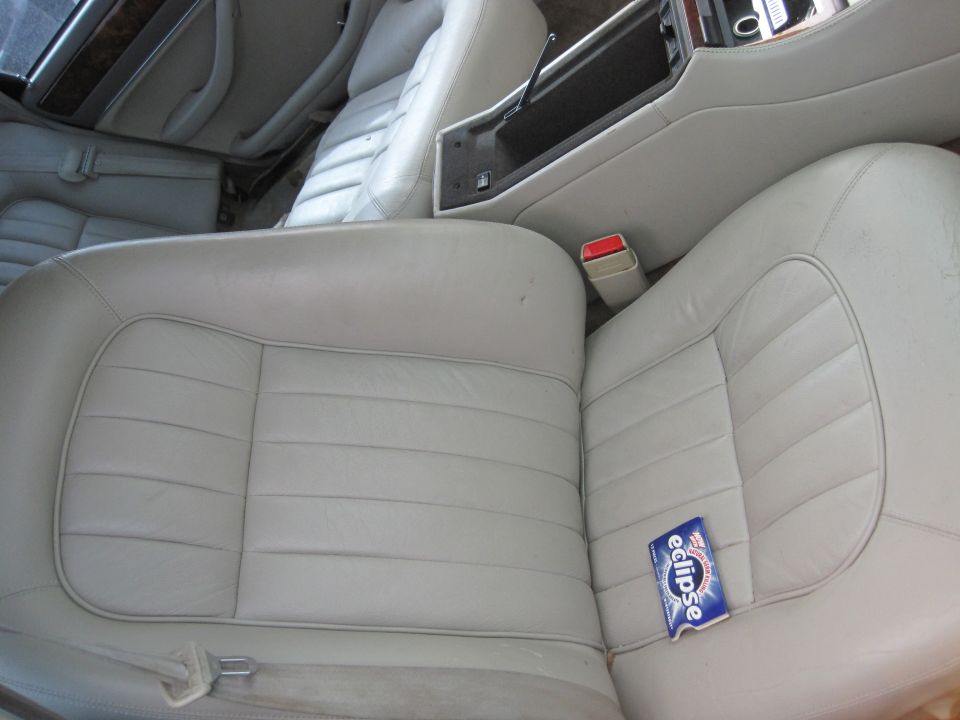 Interior of a car showing light leather seats and center console with a pack of Eclipse gum on the seat.