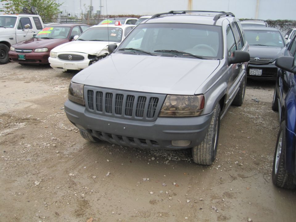 Silver Jeep Grand Cherokee front view on a dirt lot