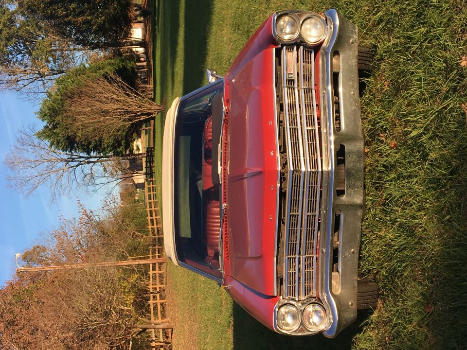 Red 1967 Ford Galaxie convertible with white top, front view.