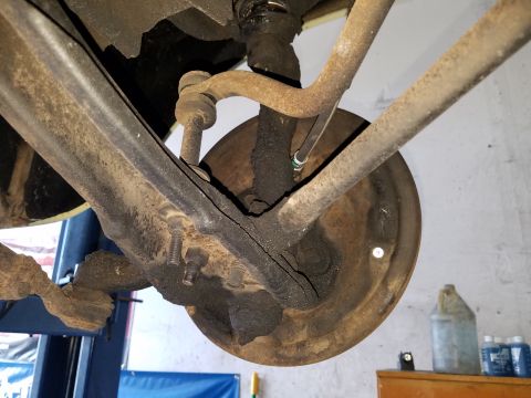 1971 Ford Mustang - This is a close-up, low-angle view of the underside of a vehicle's suspension and braking system, likely a drum brake assembly. The compone…