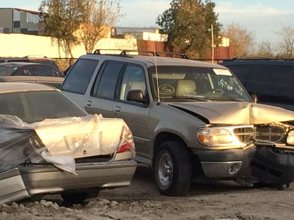 Gold SUV with front-end damage, parked next to a silver sedan