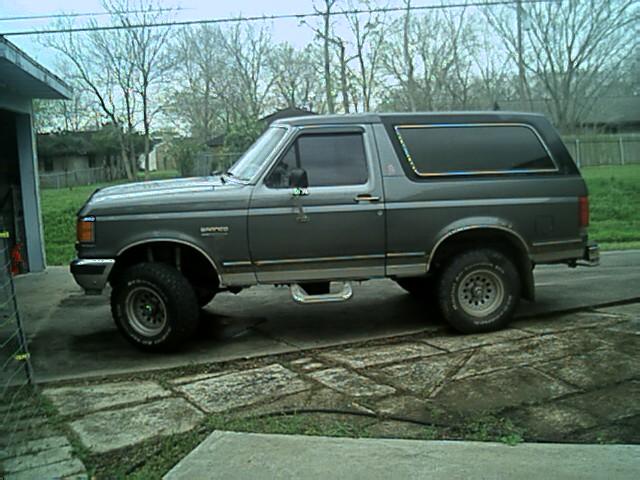 Gray full-size Ford Bronco, driver-side profile on a concrete driveway