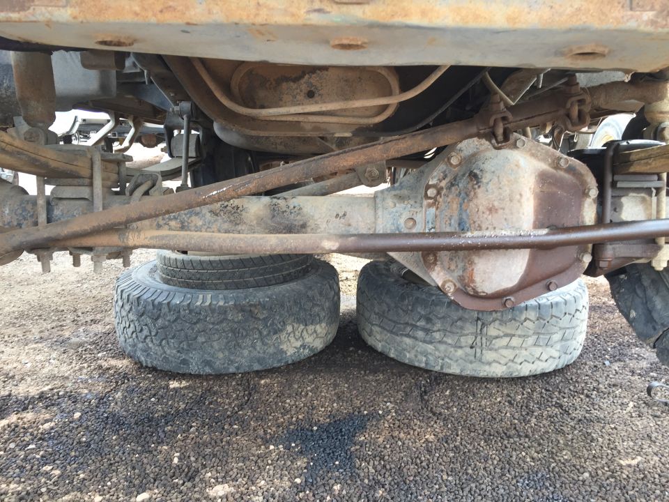 Undercarriage of a rusty vehicle with leaf springs and a differential, supported by tires