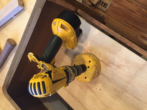 1967 Ford Custom Wagon - Power drill and hole saw bit in action on a wooden panel.