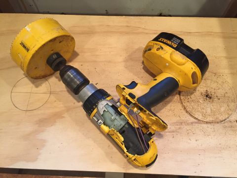 1967 Ford Custom Wagon - A DeWalt drill and a large hole saw are shown on a wooden surface, with sawdust scattered around.