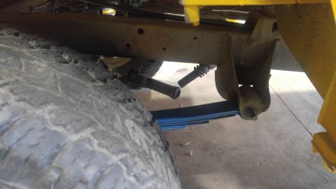 1971 Ford Bronco - Underside view of a vehicle's suspension system, focusing on the tire and leaf springs.