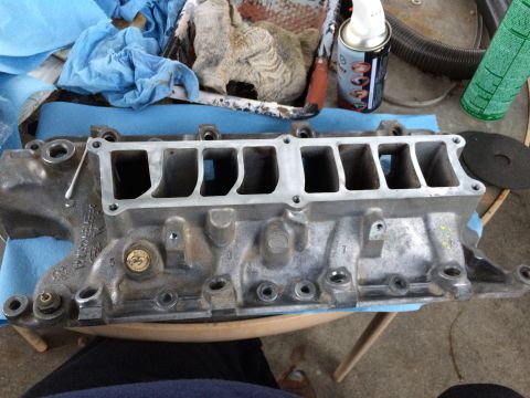 1989 Ford Bronco - An engine intake manifold sits on a table, ready for installation or cleaning.