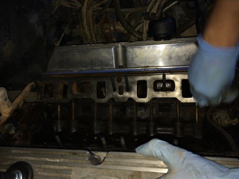 1989 Ford Bronco - Close-up view of an engine's intake manifold during maintenance, showing oily components.