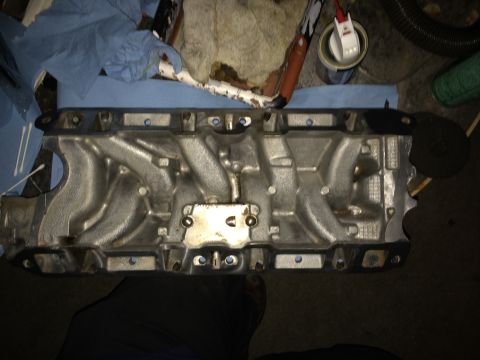 1989 Ford Bronco - Close-up of an engine intake manifold, likely for a V8 engine, during a build or repair process.