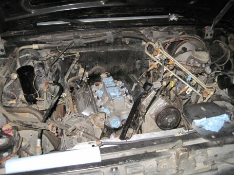1989 Ford Bronco - Engine bay with parts removed for work, showing the engine block and associated components.
