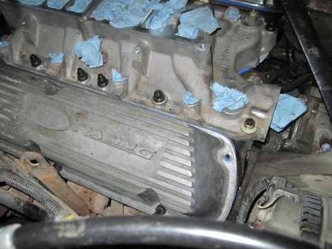 1989 Ford Bronco - Close-up of an engine's valve cover, partially covered with blue towels, suggesting maintenance or repair work.