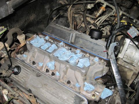 1989 Ford Bronco - Engine parts are being prepped for work, with blue paper towels covering the intake manifold ports.
