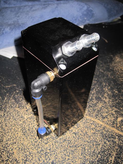 1989 Ford Bronco - A black rectangular fluid catch can with multiple fittings and clear tubing is shown.