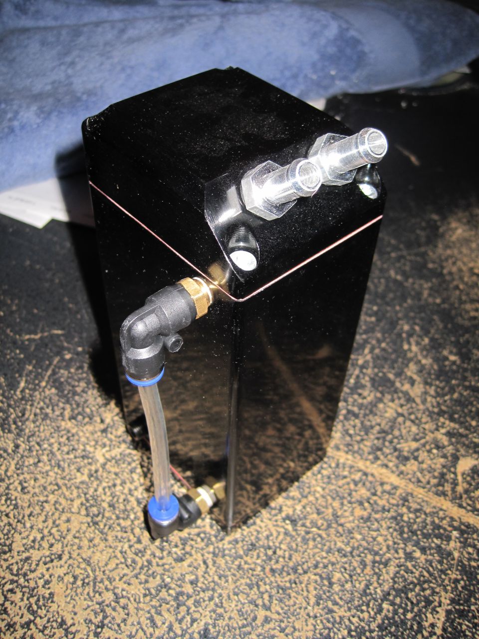 Black fluid catch can with brass and plastic fittings and clear tubing