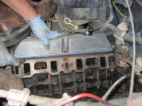 1989 Ford Bronco - Close-up view of an engine's intake manifold and gasket during a repair process.